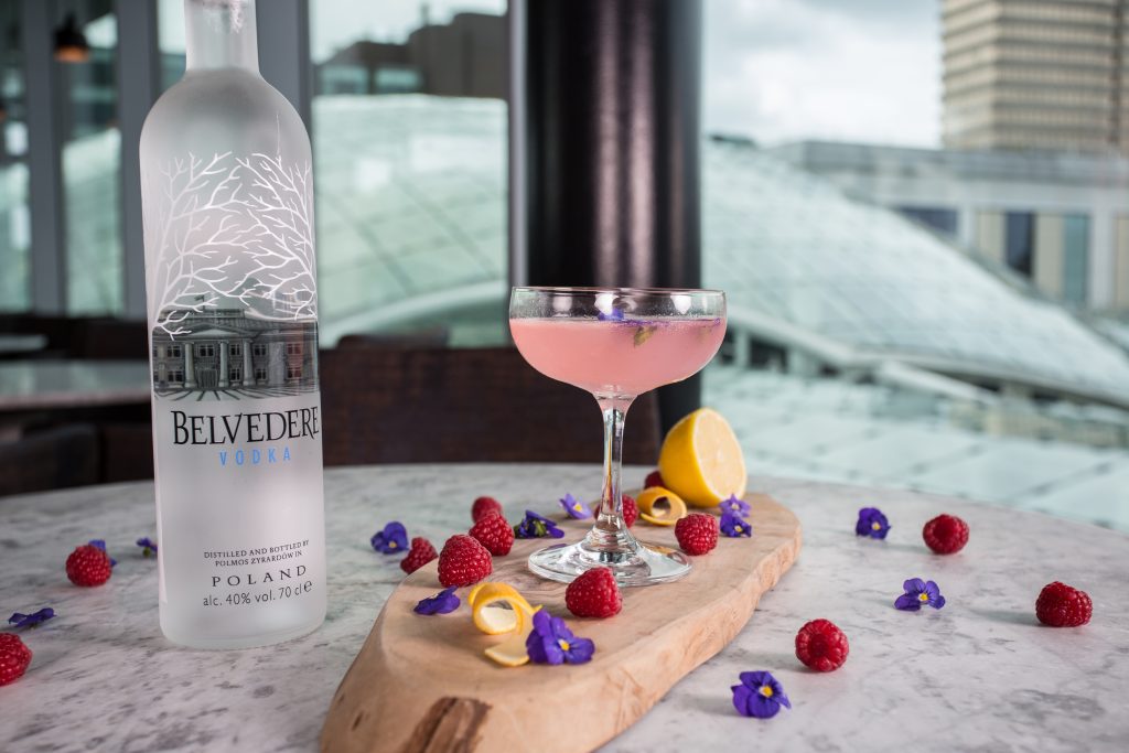 belvedere vodka, raspberries, lemon and flowers in a cocktail 
